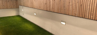 Eine Gartenmauer aus Beton mit integrierten Leuchten