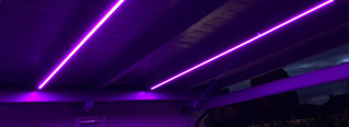 Eine beleuchtete Holzdecke mit einem lila Neonlicht